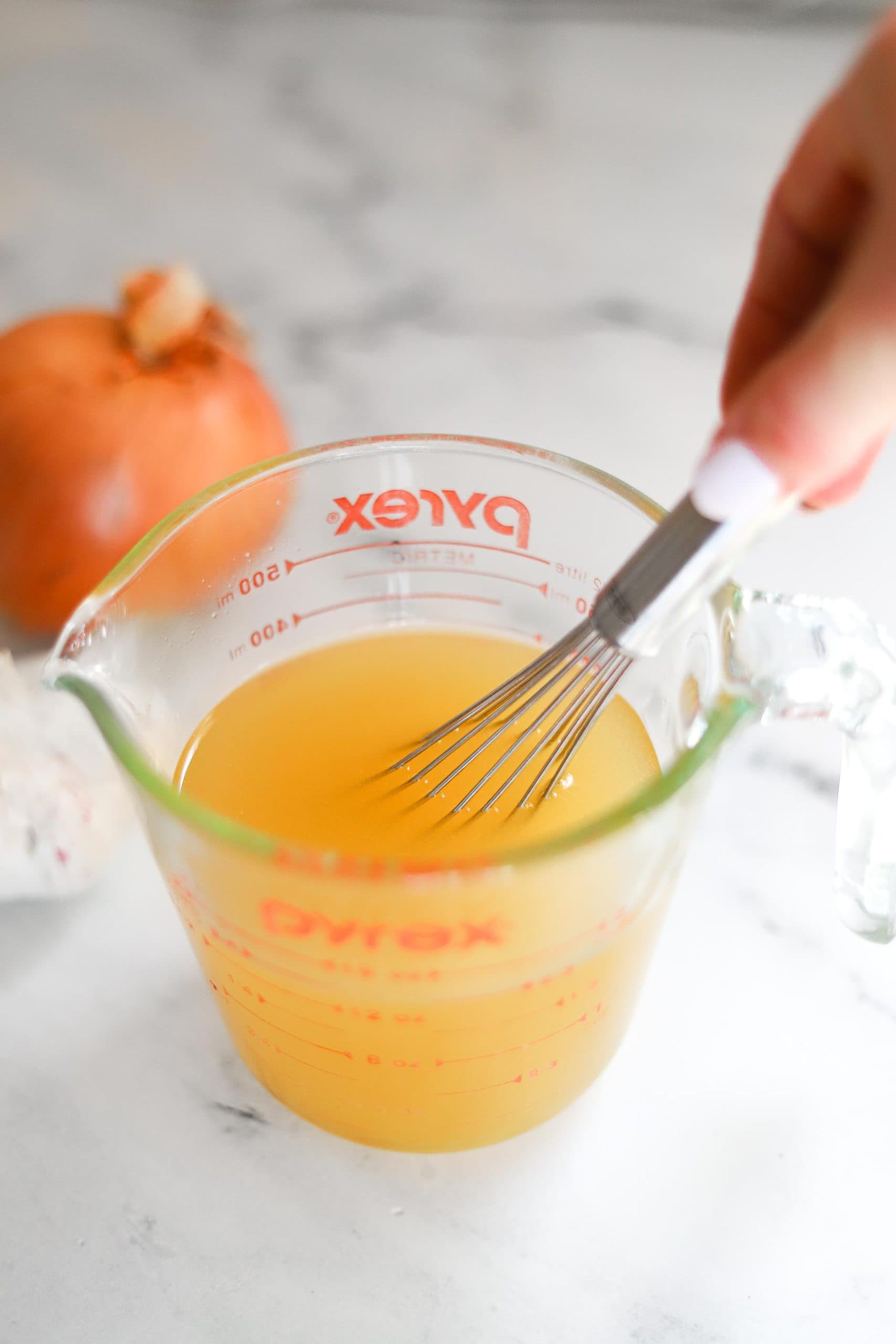 broth and wine mixed together in measuring cup